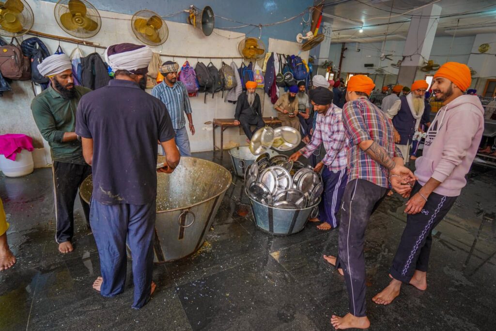 Plates flying in the dishwashing area volunteer at the Langar community kitchen at the golden temple in Amritsar.