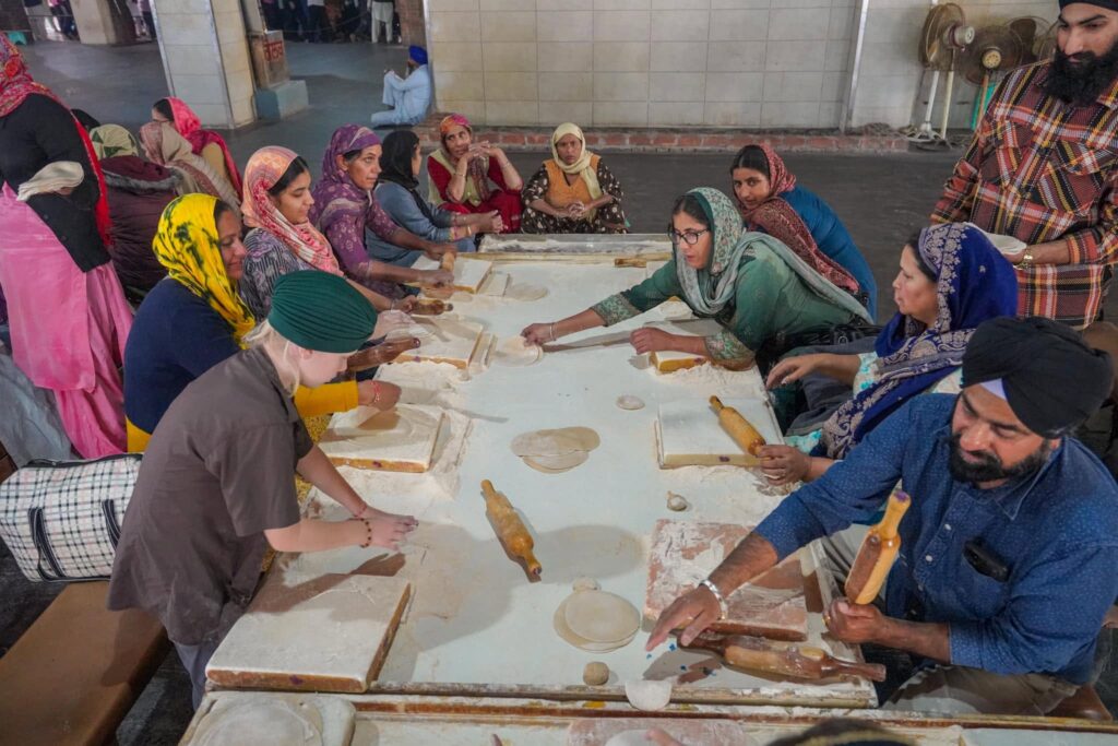 Oscar having a go making Chapati with volunteers in the Langar. 
