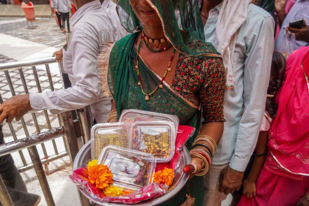 A young couple buying offerings at the Rat Temple in Bikaner, Rajasthan. 
